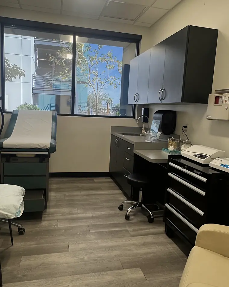 A PISO exam room with dark cabinetry and a window